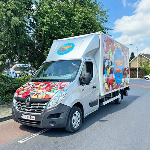 Les Folies de Lowies bestelwagen met kleurrijke snoepbedrukking onderweg voor levering van chocolade, snoep en cadeaus