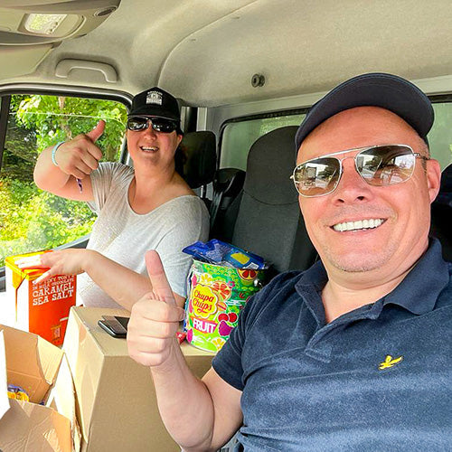 Dieter en gast in een bestelwagen met dozen snoepgoed en Chupa Chups, klaar voor levering